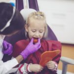 hockey player trying on sports mouthguard at the dentist