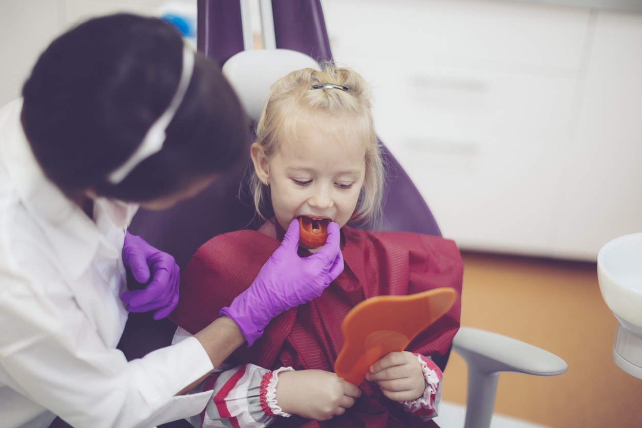hockey player trying on sports mouthguard at the dentist