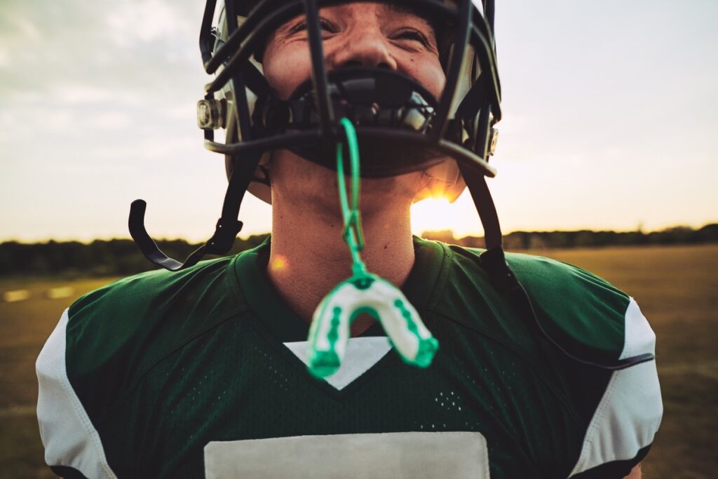 football player showing mouthguard for sports protection